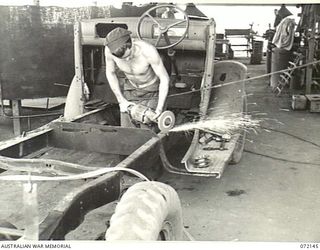 PORT MORESBY, NEW GUINEA. 1944-04-10. VX132018 CRAFTSMAN W. COLLONGS GRINDING A TRUCK CHASSIS AT THE 11TH ADVANCED WORKSHOP, AUSTRALIAN ELECTRICAL AND MECHANICAL ENGINEERS