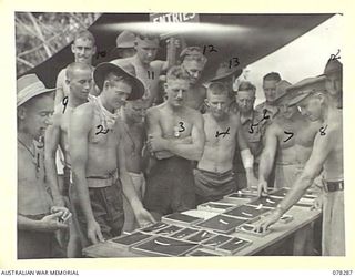 SWAN BEACH, NEW BRITAIN. 1945-01-07. TROOPS ADMIRING THE TROPHIES TO BE AWARDED TO THE WINNERS OF THE EVENTS AT THE SWIMMING AND BOATING CARNIVAL ORGANISED BY HEADQUARTERS, 13TH INFANTRY BRIGADE. ..