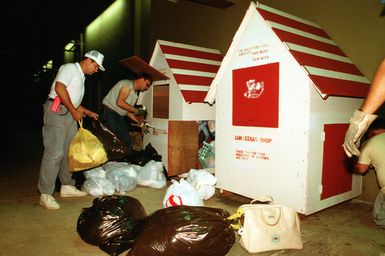 CPT Michael D'Albertis and an assistant pick up donated items for Christmas Drop, a humanitarian airdrop effort providing aid to needy islanders throughout Micronesia during the holiday season. D'Albertis, a member of the 605th Military Airlift Support Squadron, is vice chairman of the program