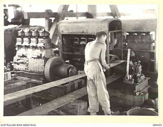 LAE, NEW GUINEA. 1944-12-21. A SOUTHERN CROSS POWER UNIT PROVIDING DIESEL MOTORS TO DRIVE MACHINERY IN AN "A" TYPE MILL AT THE UNTHANK MILL SITE. THE MILL IS OPERATED BY 2/3 FORESTRY COY MEMBERS