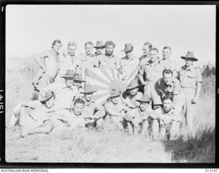 NEW GUINEA, 1942-08-28. MEMBERS OF B COMPANY, NEW GUINEA VOLUNTEER RIFLES, PROUDLY DISPLAY A JAPANESE FLAG THEY CAPTURED AT MUBO ON 1942-07-21. PERSONNEL ARE (RANK IS RIFLEMAN UNLESS STATED ..