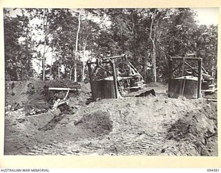 BOUGAINVILLE, 1945-07-31. TWO HEAVY TYPE BULLDOZERS OF 6 MECHANICAL EQUIPMENT COMPANY, ROYAL AUSTRALIAN ENGINEERS, WORKING IN UNISON, REMOVING THE TOP SOIL DURING THE CONSTRUCTION OF A NEW 3-TONNER ..