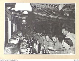 LAE, NEW GUINEA, 1945-05-23. GENERAL VIEW OF ONE OF THE TABLES AT NUMBER 3 SERGEANTS' MESS, HEADQUARTERS FIRST ARMY, SHOWING AUSTRALIAN WOMEN'S ARMY SERVICE PERSONNEL WHO ARE IN LAE TO RELEASE MEN ..
