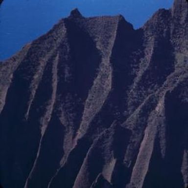 [Aerial view of eroding cliffs and distant ocean in Na Pali Coast, United States]