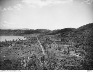 RABAUL, NEW BRITAIN, 1945-09-15. PANORAMIC VIEW OF RABAUL TOWNSHIP AND SIMPSON HARBOUR, SHOWING THE WHARF AREA AND THE DOUBLE TRACK OF MALAGUNA ROAD. THE AREA ON RIGHT OF MALAGUNA ROAD IN THE ..