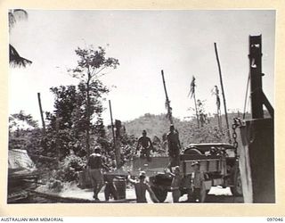 RABAUL, NEW BRITAIN. 1945-09-20. SAPPER F.G. PEGG, 55 FIELD PARK COMPANY ROYAL AUSTRALIAN ENGINEERS, SUPERVISING A JAPANESE LOADING PARTY AT THE BEACH-HEAD. THESE SUPPLIES WERE BROUGHT TO THE AREA ..