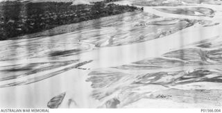 MARKHAM RIVER NEAR NADZAB, NEW GUINEA. 1943-09-05. AERIAL VIEW OF MEMBERS OF 8 PLATOON, 2/6TH FIELD COMPANY USING DECKING PLACED ACROSS FOLDING BOATS (FOLBOATS) TO MOVE MEMBERS OF 2/2ND PIONEER ..