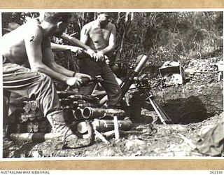 SHAGGY RIDGE, NEW GUINEA. 1943-12-27. MEMBERS OF A 3 INCH MORTAR CREW OF THE 2/16TH AUSTRALIAN INFANTRY BATTALION, 21ST AUSTRALIAN INFANTRY BRIGADE IN ACTION BOMBARDING THE "PIMPLE" PRIOR TO THE ..