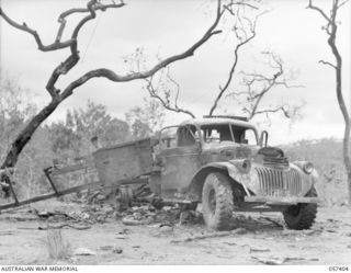 PORT MORESBY AREA, NEW GUINEA, 1943-09-14. ONE OF FIVE TRUCKS CARRYING MEMBERS OF THE 2/33RD BATTALION AND THE 158TH GENERAL TRANSPORT COMPANY, WHICH WAS DESTROYED WHEN A LIBERATOR BOMBER CRASHED ..