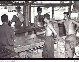 LAE, NEW GUINEA, 1946-01-09. SERGEANT G. MARKS (1), PRIVATE (PTE) F. S. CARTY (2), PTE K. HILL (3), AND PTE REES (4), IN THE DRY GOODS ISSUING POINT OF AUSTRALIAN ARMY CANTEENS SERVICE BULK STORES