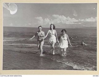 LAE, NEW GUINEA, 1945-05-18. PERSONNEL FROM AUSTRALIAN WOMEN'S ARMY SERVICE BARRACKS LEAVING THE SURF AFTER A SWIM. THEY ARE TAKING PART IN A TOUR OF THE AREA CONDUCTED BY ARMY AMENITIES SERVICE ..