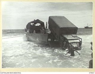 TOKO, BOUGAINVILLE, SOLOMON ISLANDS. 1945-03-21. A 3 TON TRUCK OF THE 7TH INFANTRY BRIGADE POSITIONED PRECARIOUSLY AFTER ITS ENGINE STALLED DURING UNLOADING OPERATIONS IN HEAVY SURF