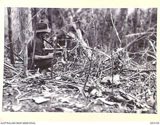 WEWAK AREA, NEW GUINEA, 1945-06-17. A DEAD JAPANESE SOLDIER LYING ACROSS AN AIRCRAFT GUN, THAT WAS USED TO HOLD UP THE ADVANCE ON HILL 2 BY B COMPANY, 2/8 INFANTRY BATTALION. IN THE BACKGROUND IS ..