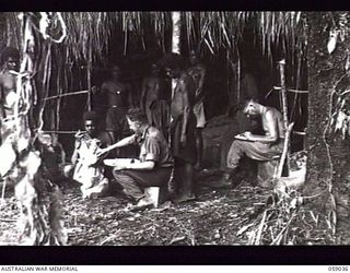 GUY'S POST, NEW GUINEA. 1943-10-22. SX13013 LIEUTENANT M. V. BARLOW (LEFT) AND SX8069 DRIVER P. P. CAMPBELL OF THE 2/2ND AUSTRALIAN SUPPLY TRANSPORT COMPANY CHECKING SUPPLIES AT THE DETAILS ISSUING ..