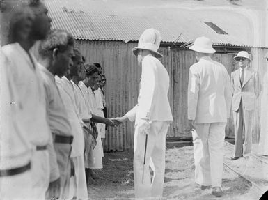 [Men in military uniform addressing Pacific islander people]