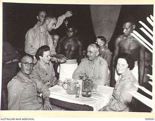 LAE, NEW GUINEA, 1945-11-25. OFFICERS BEING SERVED AT THE AUSTRALIAN ARMY CANTEENS SERVICE OFFICERS' CLUB, WHICH IS SITUATED ON THE BANKS OF THE BUSU RIVER. ANY DIFFICULTIES THAT ARISE ARE ..