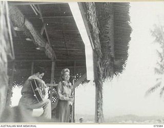 MILILAT, NEW GUINEA. 1944-08-31. FRANCES LANGFORD, SINGER OF THE BOB HOPE CONCERT PARTY, SINGING AT THE MICROPHONE DURING A CONCERT STAGED BY THE PARTY FOR ALLIED SERVICE PERSONNEL AT THE AMERICAN ..