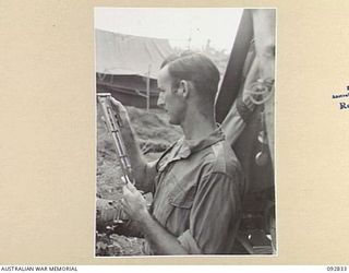 WEWAK AREA, NEW GUINEA. 1945-06-05. WARRANT OFFICER C.J. PADDICK, 3 MOBILE METEOROLOGICAL FLIGHT, RAAF, ATTACHED HEADQUARTERS ROYAL AUSTRALIAN ARTILLERY 6 DIVISION, READING THE PSYCHROMETER FOR ..