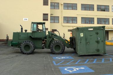 US Marine Corps (USMC) Sergeant (SGT) Wills, assigned to Combat Service Support Group 3 (CSSG-3), Marine Forces Pacific (MARFORPAC) uses a Rough Terrain Forklift to upload a Combat Camera and Printing (CC&P) portable transport van onto a transport truck at Camp H.M. Smith, Hawaii (HI), as the Unit prepares for deployment to Iraq, in support of Operation IRAQI FREEDOM