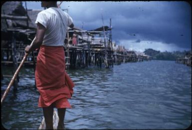 Tupesleia village, a man navigating amongst the houses : Port Moresby, Papua New Guinea, 1953 / Terence and Margaret Spencer