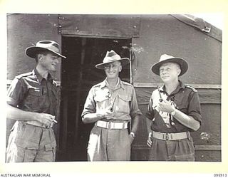 WEWAK POINT, NEW GUINEA. 1945-08-29. LIEUTENANT COLONEL W.S. HOWDEN, COMMANDING OFFICER, 2/8 INFANTRY BATTALION (2), WITH TWO OF HIS OFFICERS OUTSIDE HIS OFFICE. IDENTIFIED PERSONNEL ARE:- MAJOR D. ..