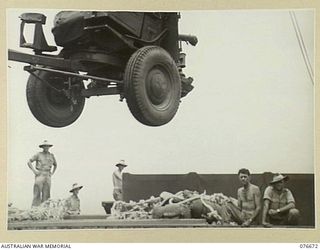 JACQUINOT BAY, NEW BRITAIN. 1944-11-04. A TANK ATTACK GUN BEING SWUNG OVER THE SIDE OF THE TROOPSHIP "CAPE ALEXANDER" AS THE VESSEL IS BEING UNLOADED BY THE TROOPS OF THE 33RD DOCKS OPERATING ..