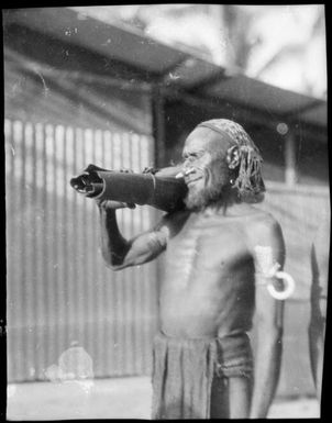 Bearded man with a bark parcel on his shoulder, Awar, Sepik River, New Guinea, 1935 / Sarah Chinnery