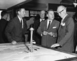 John Haydon, Ray Peterson, Senator Warren G. Magnuson and Al Rochester looking at Century 21 World's Fair Exposition: Port of Seattle exhibit, approximately 1962