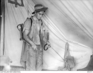 KARAWOP, NEW GUINEA, 1945-07-18. TPR A.F. AUSTIN, 2/6 CAVALRY (COMMANDO) REGIMENT SPRAYING A TENT WITH DDT INSECTICIDE. ALL TENTS IN THE KARAWOP AREA ARE SPRAYED ONCE EACH WEEK