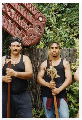 Two Maori men holding taiahas