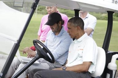 Barack Obama confers with Robert Baker after he plays golf in Kaneohe Bay, Hawaii, December 24, 2014