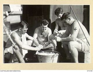 OFF MADANG, NEW GUINEA. 1944-05-14. COOKS PEELING POTATOES ABOARD HMAS BARCOO ON DECK BESIDE THE GALLEY. IDENTIFIED PERSONNEL ARE:- LEADING COOK E. BLACK (1); LEADING COOK J. DUKE (2); LEADING COOK ..