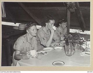 BOUGAINVILLE, 1945-04-19. PERSONNEL AT LUNCH IN THE AUSTRALIAN ARMY MEDICAL WOMEN'S SERVICE MESS, 2/1 GENERAL HOSPITAL. IDENTIFIED PERSONNEL ARE:- PRIVATE H.T. GATHENEE (1); PRIVATE E.V. BYRES (2); ..