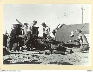 BOUGAINVILLE ISLAND. 1945-01-20. A GUN CREW OF NO. 5 BATTERY, 2ND FIELD REGIMENT, LAYING A BARRAGE DOWN ON JAPANESE POSITIONS WITH THEIR LONG 25 POUNDER. IDENTIFIED PERSONNEL ARE:- GUNNER BARTLETT ..