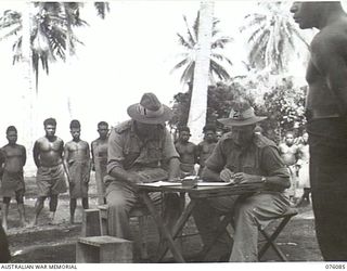 KARKAR ISLAND, NEW GUINEA. 1944-09-18. NX65453 CAPTAIN V.W. MAXWELL, AUSTRALIAN NEW GUINEA ADMINISTRATIVE UNIT (1) AND NGX31 LIEUTENANT S.L. ASHTON, RECRUITING OFFICER, AUSTRALIAN NEW GUINEA ..