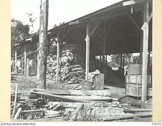 LAE, NEW GUINEA. 1944-09-27. THE TARPAULIN STORAGE SHED OF THE 43RD FIELD ORDNANCE DEPOT WITH AMBULANCE STRETCHERS IN THE FOREGROUND