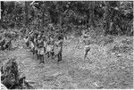 Elota, the priest, circles the dancers 8 times ritually; note pig skull on his left hip