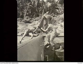 TADJI AIRSTRIP, AITAPE, NORTH EAST NEW GUINEA. 1945-03-30. AIRFRAME EXPERTS DISMANTLING THE TAIL OF A BEAUFORT BOMBER AIRCRAFT OF NO. 100 SQUADRON RAAF WHICH HAS BEEN IN OPERATIONS AGAINST THE ..