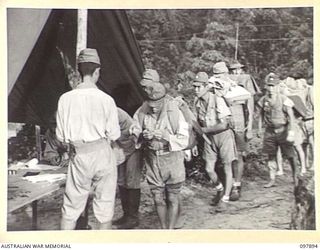 KAHILI, BOUGAINVILLE. 1945-09-30. JAPANESE TROOPS LINED UP TO RECEIVE NUMBERED IDENTITY DISCS BEFORE BEING MOVED TO THE CONCENTRATION AREA ON FAURO ISLAND. JAPANESE OFFICERS CHECKED THE ROLLS AND ..