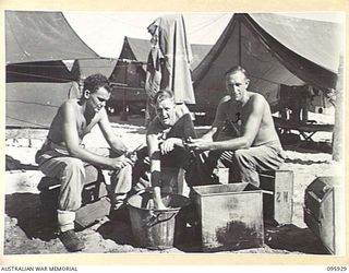 BORAM BEACH, WEWAK AREA, NEW GUINEA. 1945-08-30. MEMBERS OF HEADQUARTERS 8 INFANTRY BRIGADE, ON DUTY PEELING POTATOES