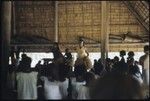 Dancers with grass skirts performing in a building