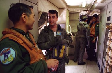 Crewman AD2 (NAC) Anthony Corcoran (second from left) and AE2 (NAC) Richard Parezrosa (second from right) from Patrol Squardron 4 (VP-4) explain emergency procedures to Japanese Maritime Self Defense Force (JMSDF) Detachment 33 aircrewmen Takeshi Okamato (left) and Fumio Sato (right) during a crosstraining mission of Japan and U.S. Bilateral Force as part of the exercise Rimpac 98