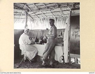 CAPE WOM, WEWAK AREA, NEW GUINEA. 1945-08-28. SISTER S.B.M. BOWMAN, AUSTRALIAN ARMY NURSING SERVICE 104 CASUALTY CLEARING STATION AND MAJOR B.H. VERNER, CHECKING MEDICAL HISTORY SHEETS IN THE ..