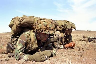 PVT. 2 Fernando Gonzales and PFC. Michael Narris of Charlie Company, 1ST/19th Scout Platoon, await the 25th Combat Aviation Bn. UH-1A Iroquois helicopter that will pick them up for an air assault during exercise Opportune Journey 4-84