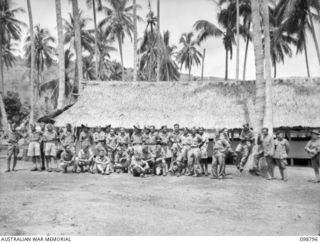 KERAVIA BAY, NEW BRITAIN. 1945-11-12. A GROUP OF AMBON NATIVE BOYS OUTSIDE THEIR BARRACKS AT THE ROYAL NETHERLANDS EAST INDIES ARMY CAMP, WHERE SOME 150 ROYAL NETHERLANDS EAST INDIES EX-PRISONERS ..