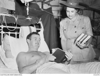 TOROKINA, BOUGAINVILLE ISLAND, SOLOMON ISLANDS. C. 1945-02-23. SENIOR RED CROSS REPRESENTATIVE SHEILA GRAHAM OF SYDNEY, NSW, WHOSE DUTIES INCLUDE VISITS TO RAAF HOSPITAL TO SUPPLY COMFORTS TO SICK ..