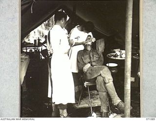 KILIGIA, NEW GUINEA. 1944-03-13. VX81008 CAPTAIN W.A. DOTT (2), OFFICER COMMANDING "E" SECTION, 2/5TH DENTAL UNIT, FILLING A TOOTH FOR A SOLDIER ASSISTED BY VX100190 PRIVATE R. CREEK (1), ..