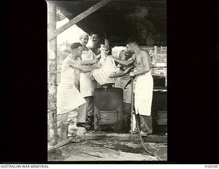 PORT MORESBY, PAPUA. 1942-12-25. COOKS FROM A RAAF SQUADRON PUTTING A CHRISTMAS PUDDING INTO A BOILER. LEFT TO RIGHT: LEADING AIRCRAFTMAN (LAC) L. J. ANDERSON, HOLBROOK, NSW; LAC R. C. LOTT, BURRA, ..