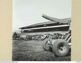LAE, NEW GUINEA. 1944-09-27. ANTI-AIRCRAFT GUNS AND 25 POUNDERS PARKED OUTSIDE THE ORDNANCE WORKSHOPS OF THE 43RD FIELD ORDNANCE DEPOT