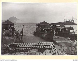 RABAUL, NEW BRITAIN. 1945-11-20. JAPANESE SHELL CASES FROM KOKOPO BEING UNLOADED BY A JAPANESE WORKING PARTY. SALVAGED JAPANESE AMMUNITION IS BEING STORED IN 11 DIVISION AREA